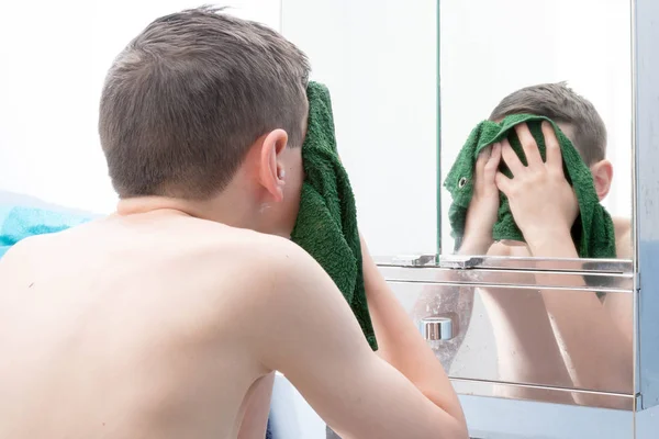 Młody chłopak nastoletnich mycia twarzy z flaneli — Zdjęcie stockowe