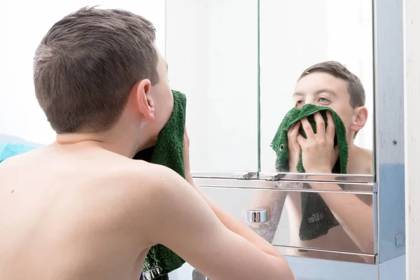 Молодий хлопчик-підліток миє обличчя з фланеллю — стокове фото