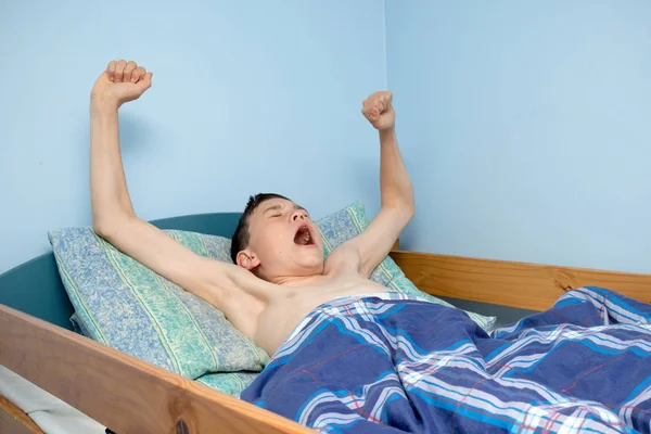 Jovem caucasiano adolescente menino acordar na cama — Fotografia de Stock