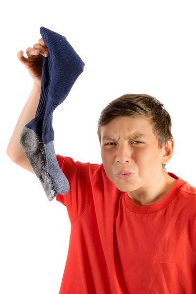 Joven adolescente aislado sobre un fondo blanco sosteniendo un calcetín de olor — Foto de Stock
