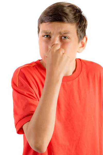 Young teenage boy isolated on a white background holding his nose — Stock Photo, Image