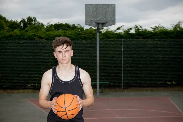Remaja laki-laki memegang basket di lapangan — Stok Foto