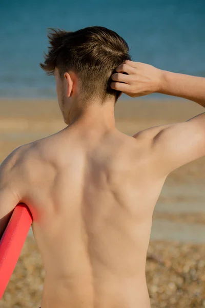 Tizenéves fiú test deszkán tartja a strandon — Stock Fotó