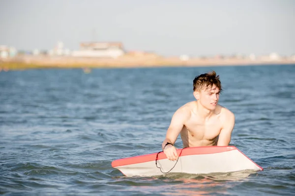 海でボディー ボードと 10 代の少年 — ストック写真