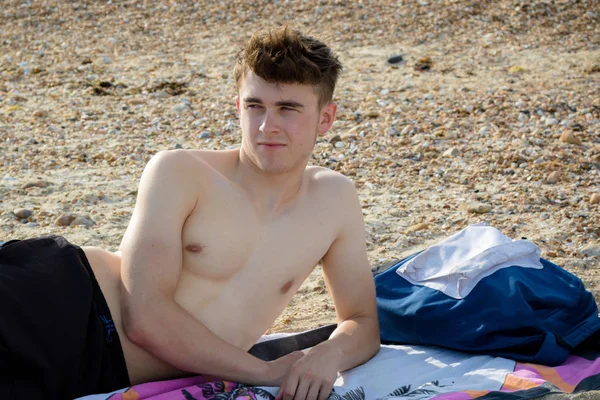 Teenager liegt auf einem steinigen Strand — Stockfoto