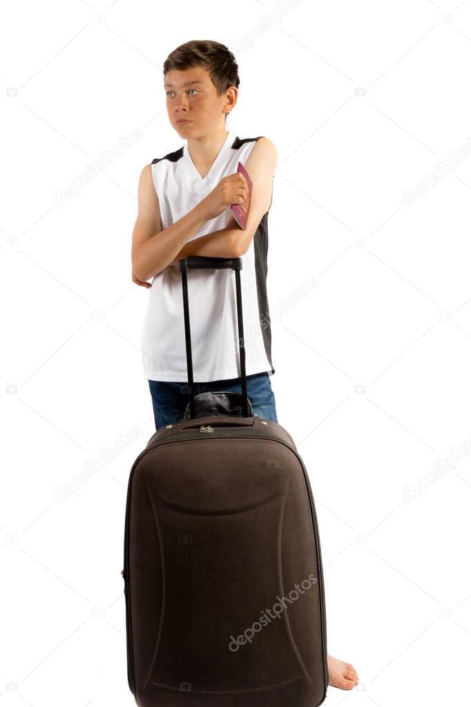Young teenage boy isolated on white waiting with a suitcase and 