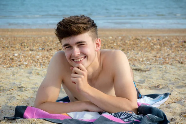 Teenager liegt auf einem steinigen Strand — Stockfoto