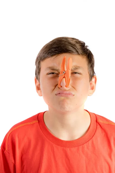 Young teenage boy isolated on a white background with a clothes peg on his nose — Stock Photo, Image