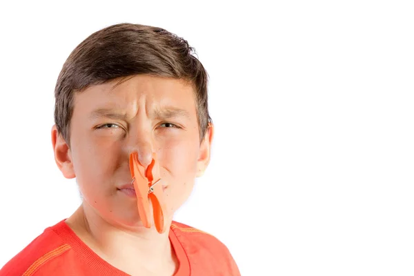 Young teenage boy isolated on a white background with a clothes peg on his nose — Stock Photo, Image