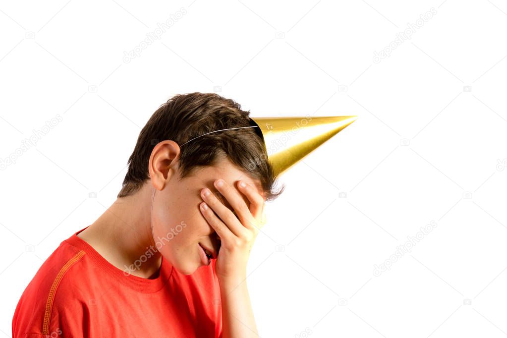 Young teenage boy isolated on white covering his eyes at a party