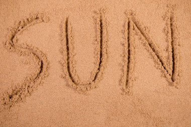 Yumuşak ıslak kum bir plajda yazılmış güneş