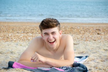 Genç çocuk stoney kumsalda döşeme