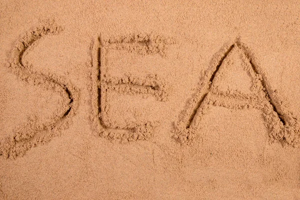 Yumuşak ıslak kum bir plajda yazılmış deniz