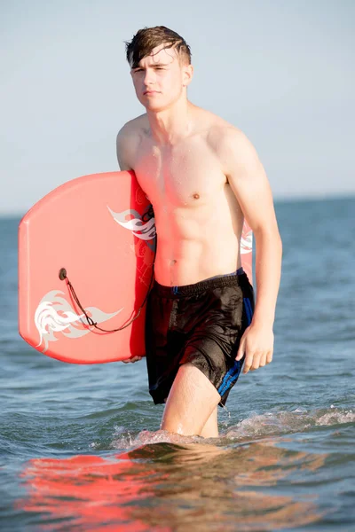 Adolescente con un body board en el mar — Foto de Stock