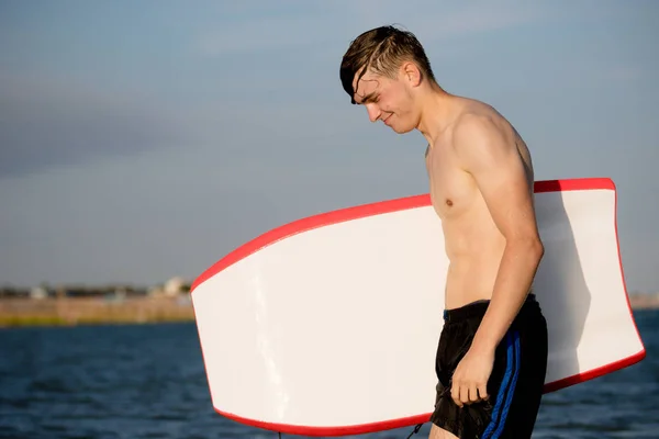 Adolescente con un body board en el mar — Foto de Stock