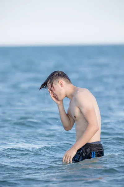 Teenage boy in the sea on a summer's day — Stock Photo, Image