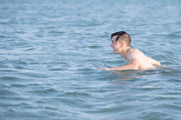 Teenage boy in the sea on a summer's day — Stock Photo, Image