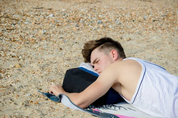 Teenager liegt auf einem steinigen Strand — Stockfoto
