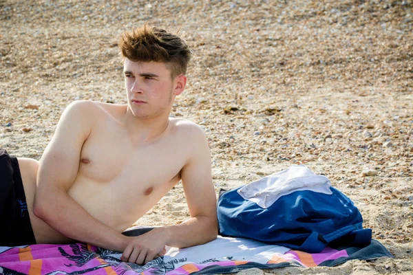 Teenager liegt auf einem steinigen Strand — Stockfoto