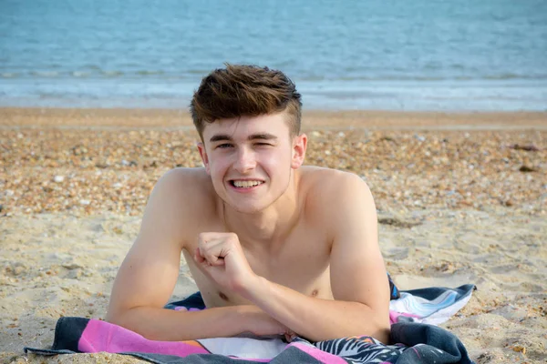 Genç çocuk stoney kumsalda döşeme