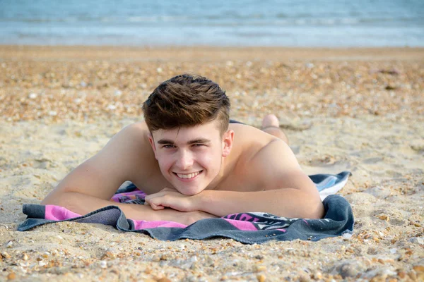 Teenager liegt auf einem steinigen Strand — Stockfoto