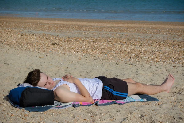 十几岁的男孩躺在托尼的海滩上 — 图库照片