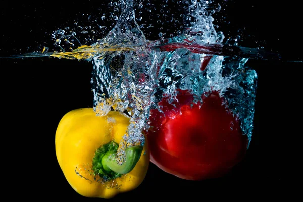 Droped papriky žluté & červené Bell do vody — Stock fotografie