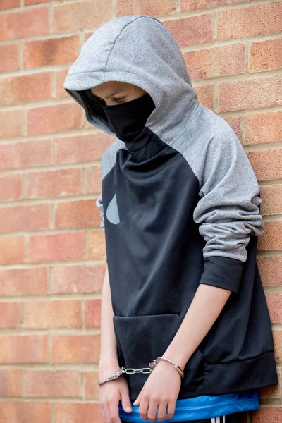 Young caucasian teenage boy in handcuffs after being arrested — Stock Photo, Image