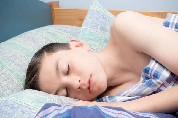 若い白人 10 代の少年が彼のベッドで眠っています。 — ストック写真