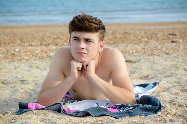 Genç çocuk stoney kumsalda döşeme