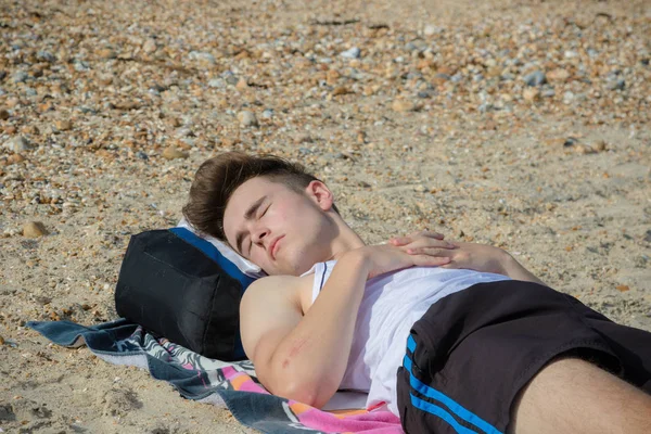 Teenager liegt auf einem steinigen Strand — Stockfoto