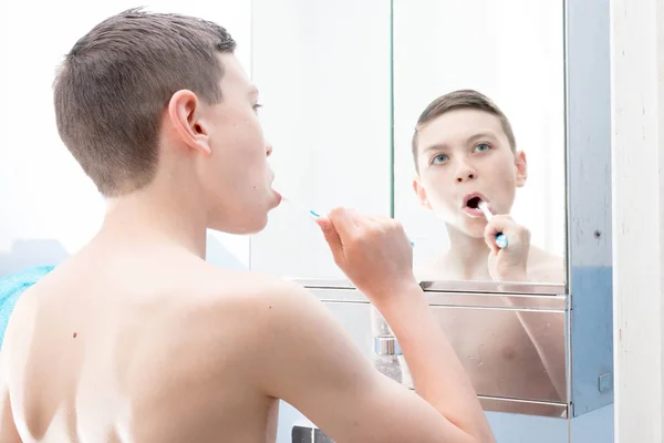 Joven adolescente caucásico cepillándose los dientes — Foto de Stock