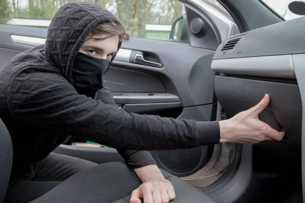 Mascarado adolescente criminoso roubando de um carro — Fotografia de Stock