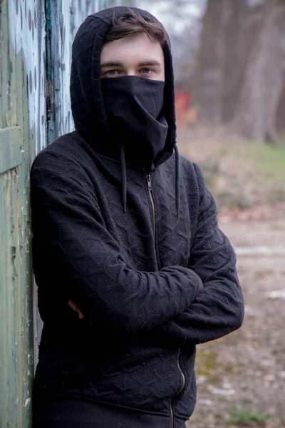 Teenage boy with his face hidden by a mask — Stock Photo, Image