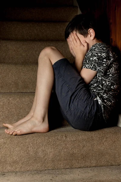 Rapaz triste sentado em algumas escadas — Fotografia de Stock