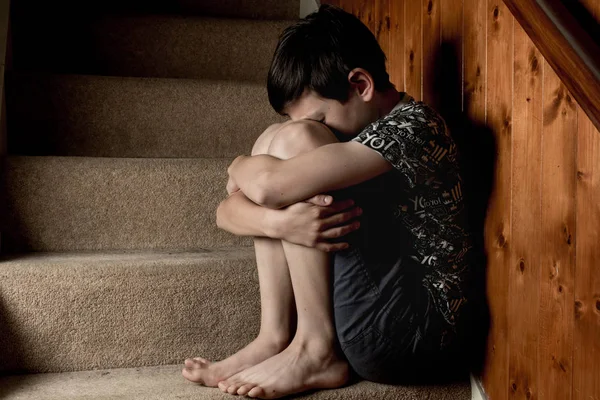 Smutny chłopiec siedzący na schodach — Zdjęcie stockowe