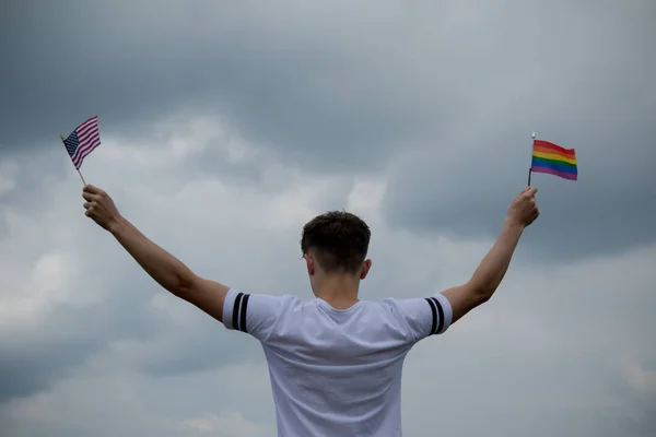 Menino adolescente com bandeira dos Estados Unidos e uma bandeira do orgulho — Fotografia de Stock