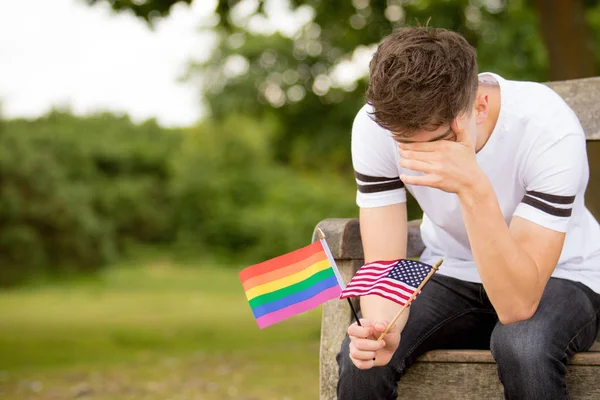 Deprimido adolescente con bandera de los Estados Unidos y una bandera de orgullo — Foto de Stock