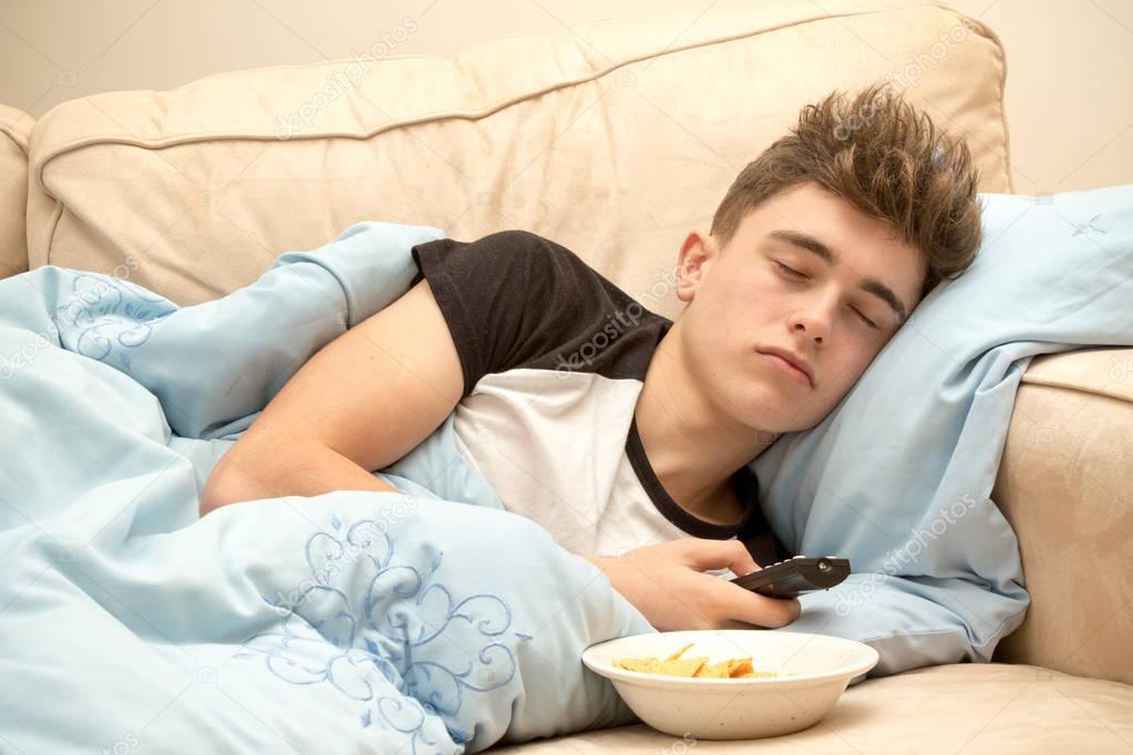 Teenage boy sleeping on a sofa
