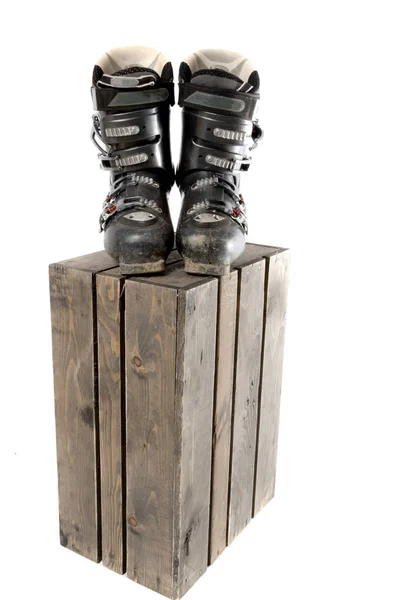 Grey well worn ski boots on a wooden crate — Stock Photo, Image