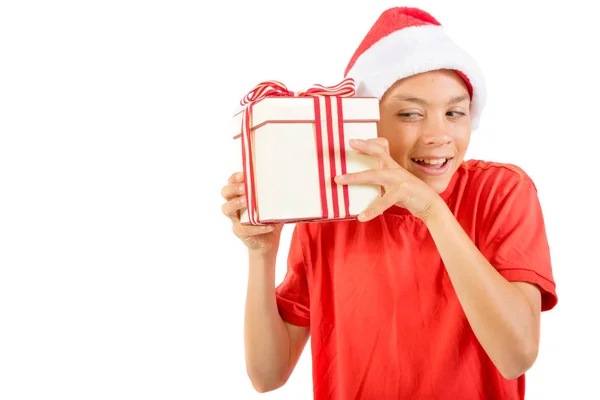年轻的男孩戴着圣诞老人的圣诞帽带着礼物 — 图库照片