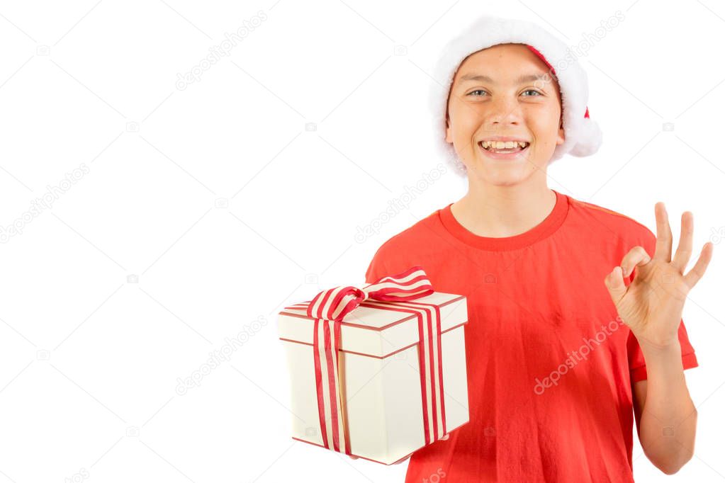Young teenage boy wearing a Santa Christmas hat with a gift
