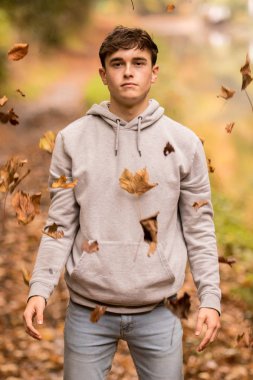 Genç çocuk ve düşen yaprakları