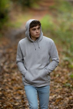 Genç çocuk tek başına bir atumn gününde yürüyüş