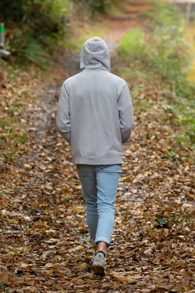 Teenage boy walking alone on an atumn day