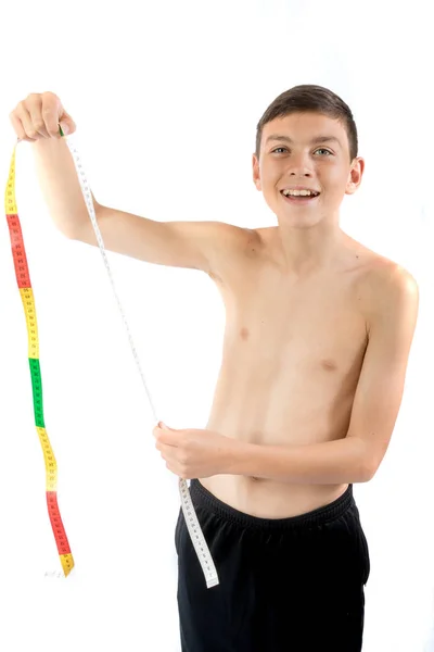 Adolescent garçon regarder un ruban à mesurer — Photo