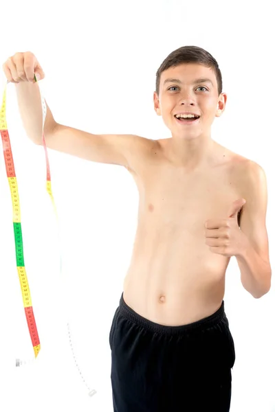 Adolescente olhando para uma fita métrica — Fotografia de Stock
