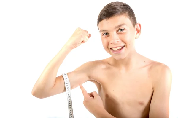 Menino adolescente medindo seu bíceps — Fotografia de Stock