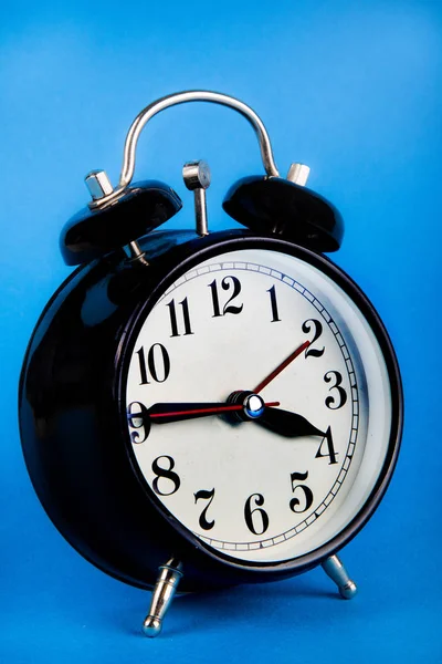 Reloj despertador negro sobre fondo azul —  Fotos de Stock