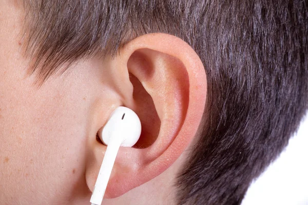 Young caucasian teenage boy's ear and headphone — Stock Photo, Image
